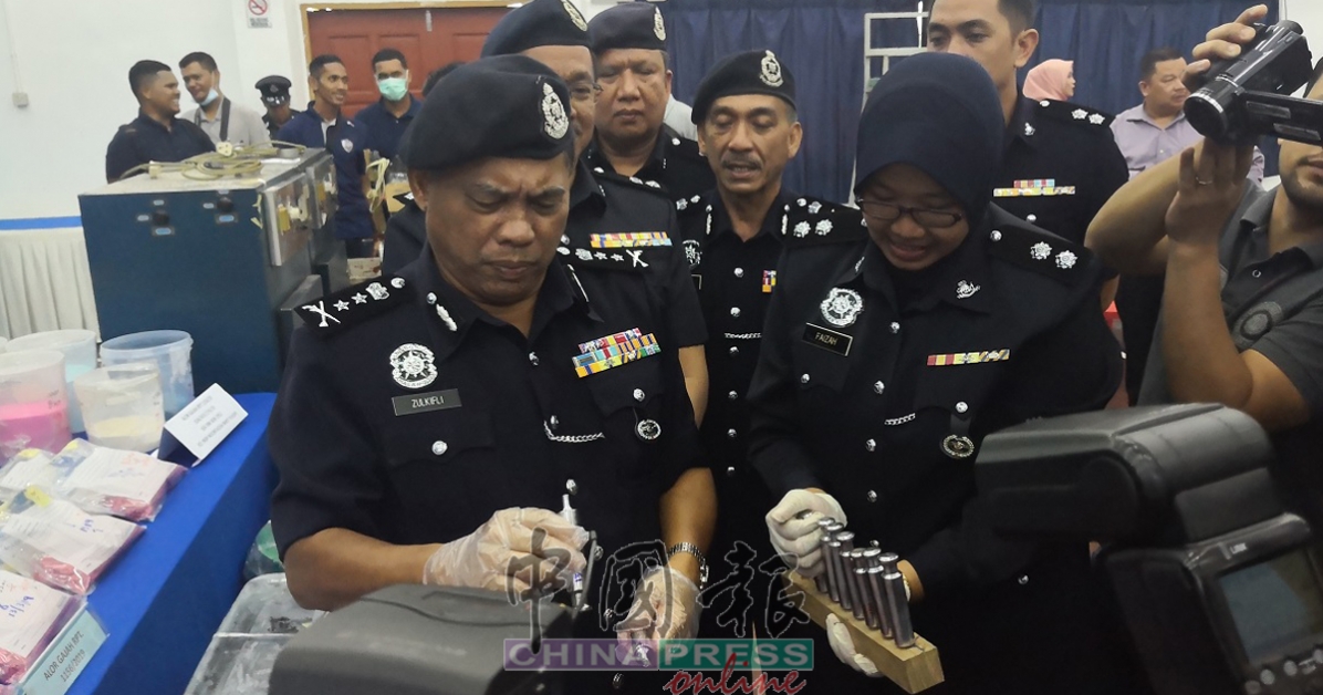 祖基菲里(左)查看制造毒品的工具。